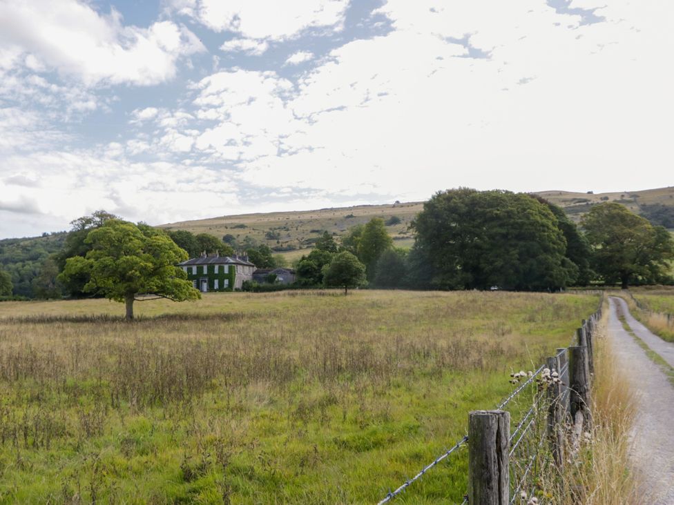 A house and trees in a field at The Gameskeepers Cottage in Cartmel