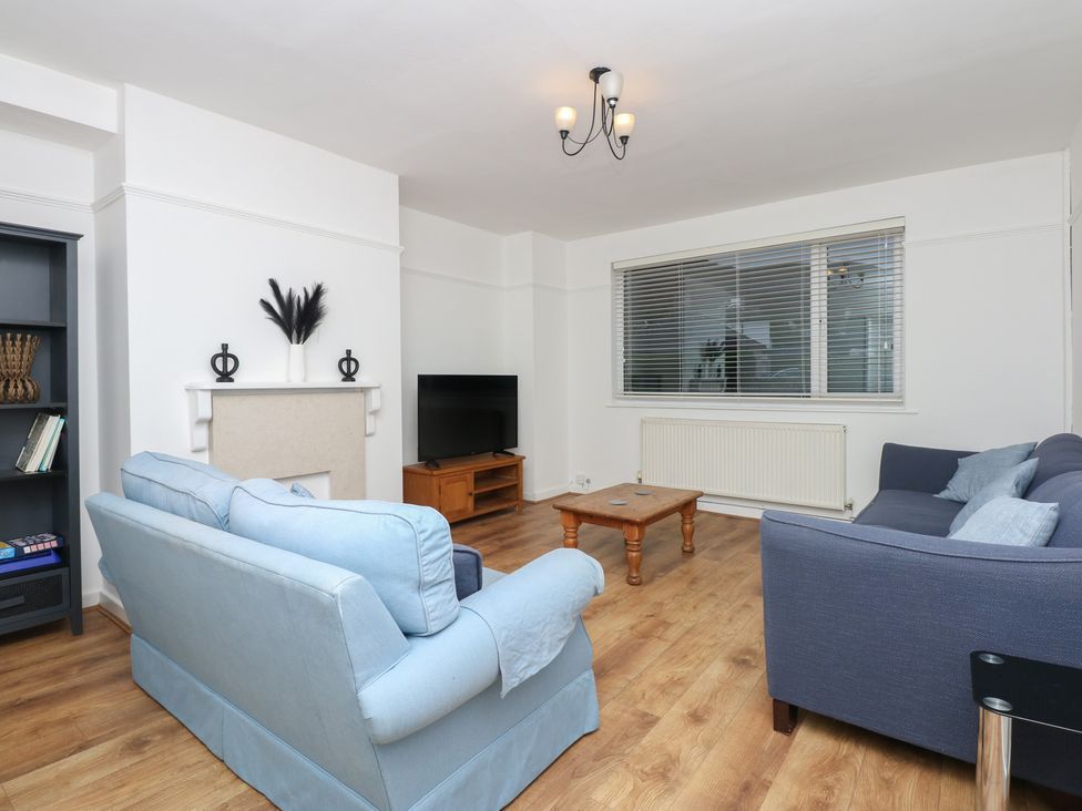 A living room with sofas, a coffee table, and a television at Tan Y Mynydd in Dwygyfylchi