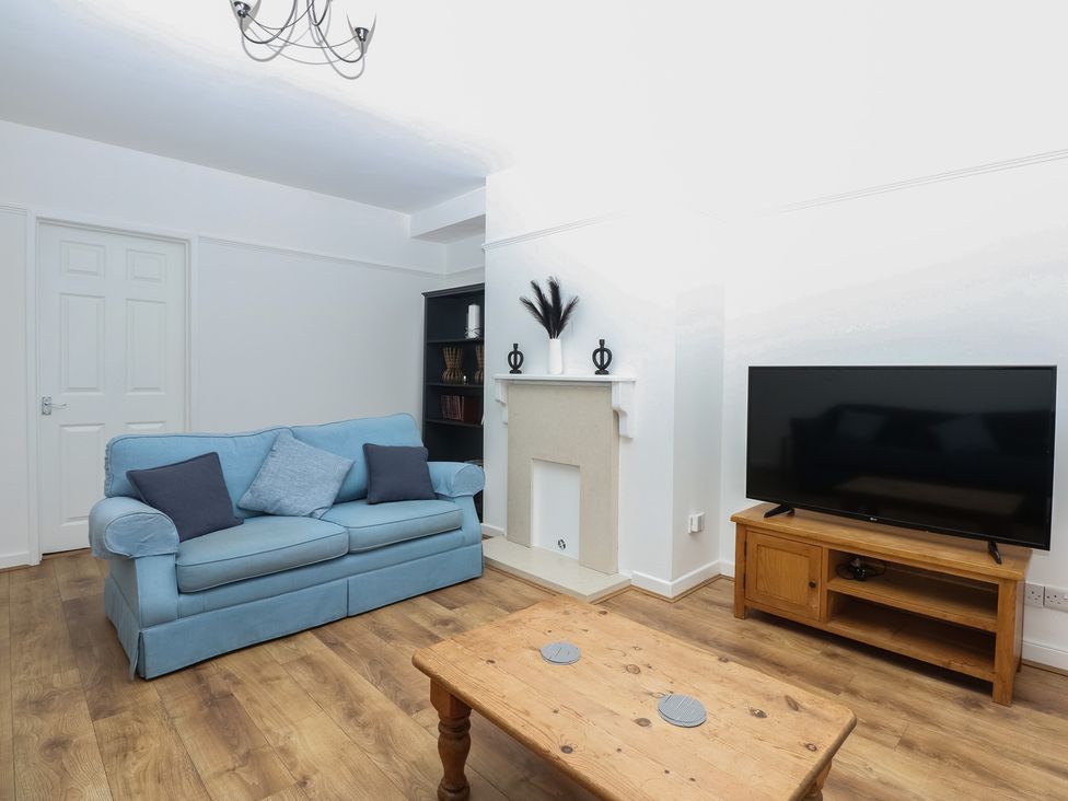 A living room with a sofa and television at Tan Y Mynydd in Dwygyfylchi