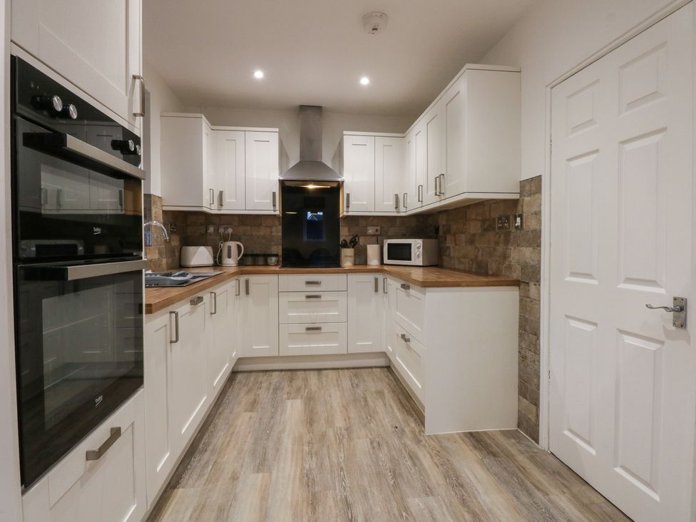 A kitchen with cabinets and appliances at Tan Y Mynydd in Dwygyfylchi