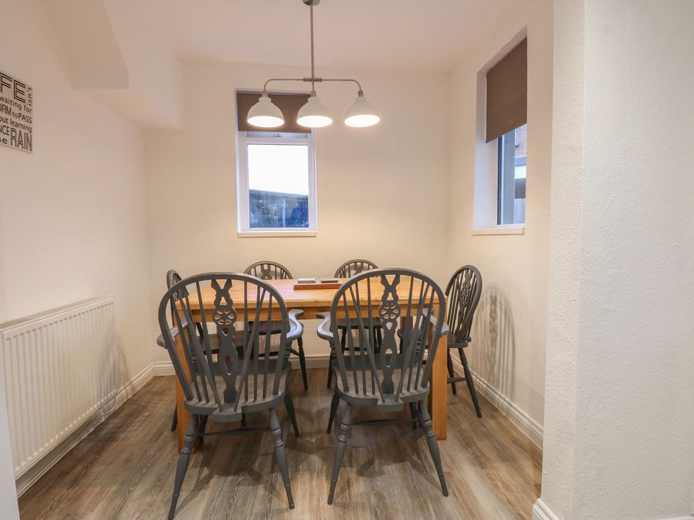 A dining room with a wooden table and chairs at Tan Y Mynydd in Dwygyfylchi