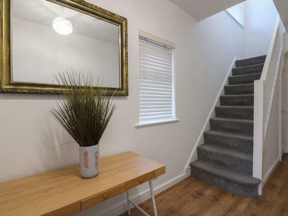 A hallway with a table and mirror at Tan Y Mynydd in Dwygyfylchi