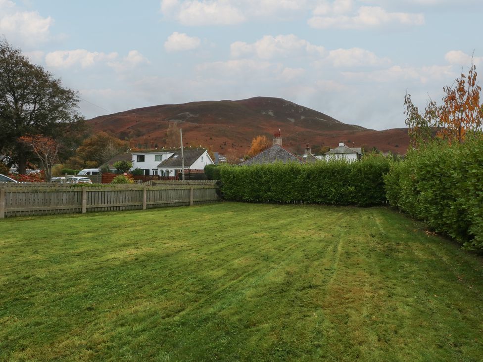 A garden with grass and fence at Tan Y Mynydd in Dwygyfylchi