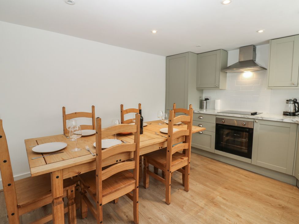 A dining room with a wooden table and chairs at Salvin Cottage in Alston