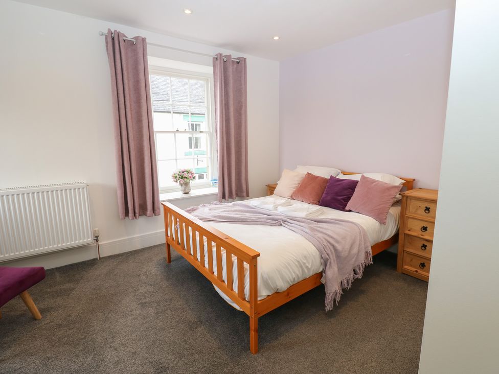 A bedroom with a bed, dresser, and window at Salvin Cottage in Alston