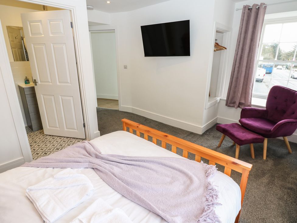 A bedroom with a bed and a television at Salvin Cottage in Alston