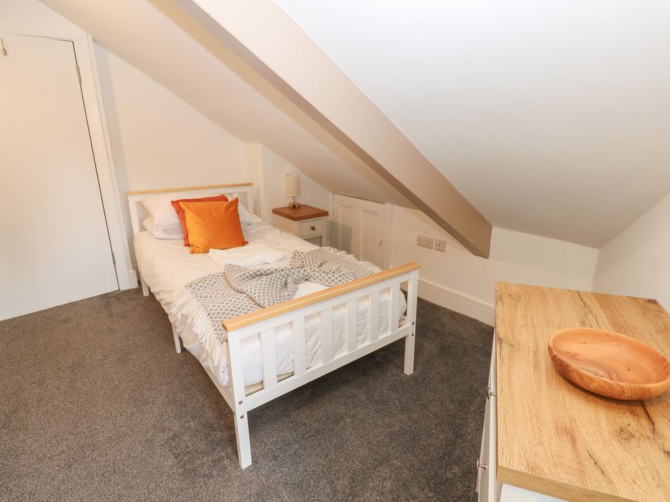 A bedroom with a single bed and wooden table at Salvin Cottage in Alston