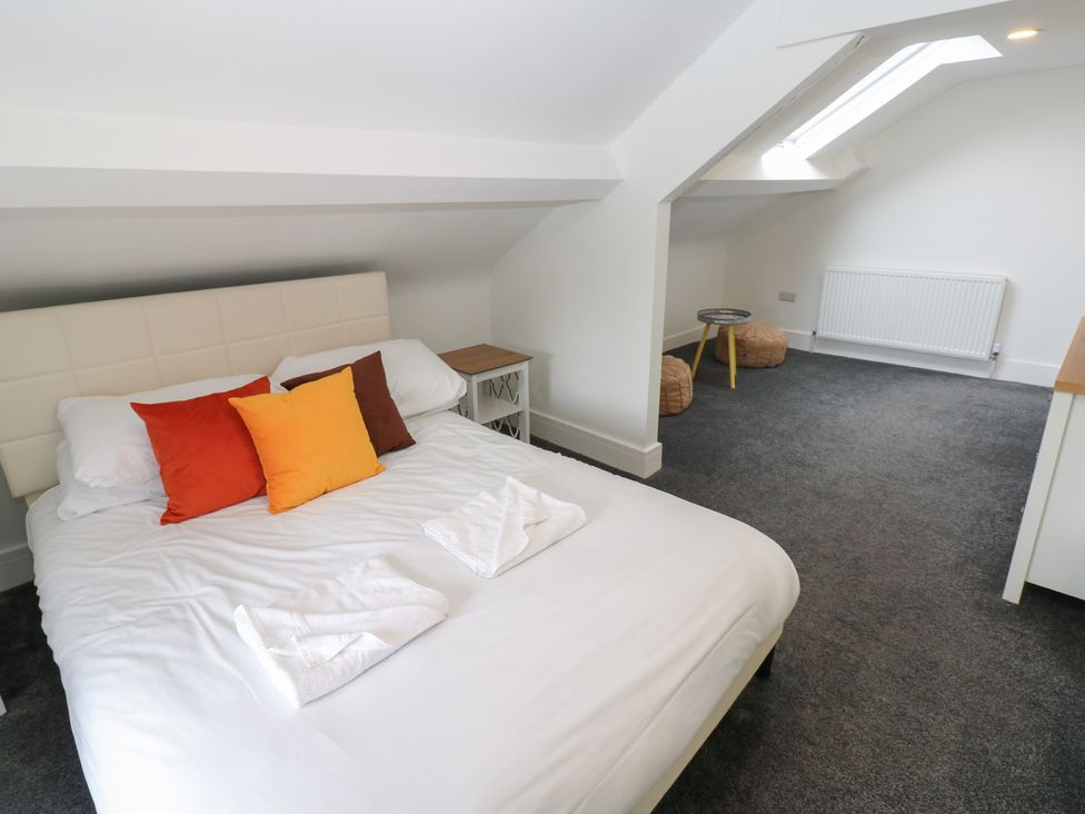 A bedroom with a bed and table at Salvin Cottage in Alston