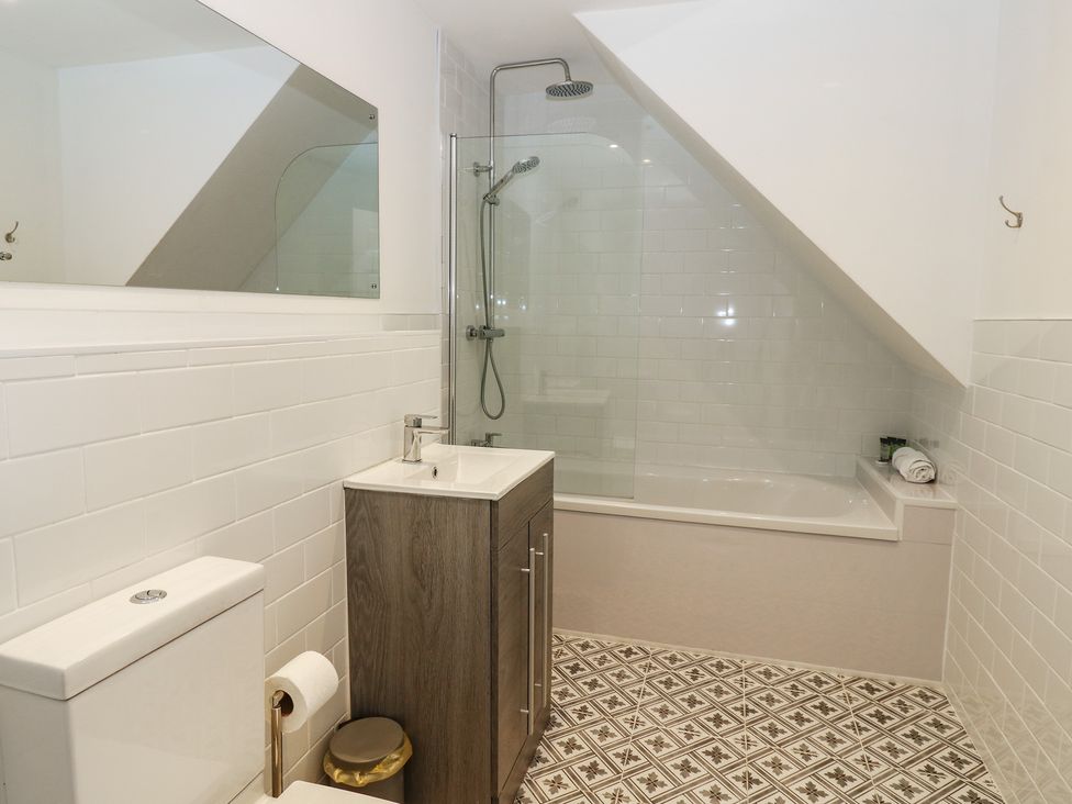 A bathroom with toilet, sink, shower, and bathtub at Salvin Cottage in Alston