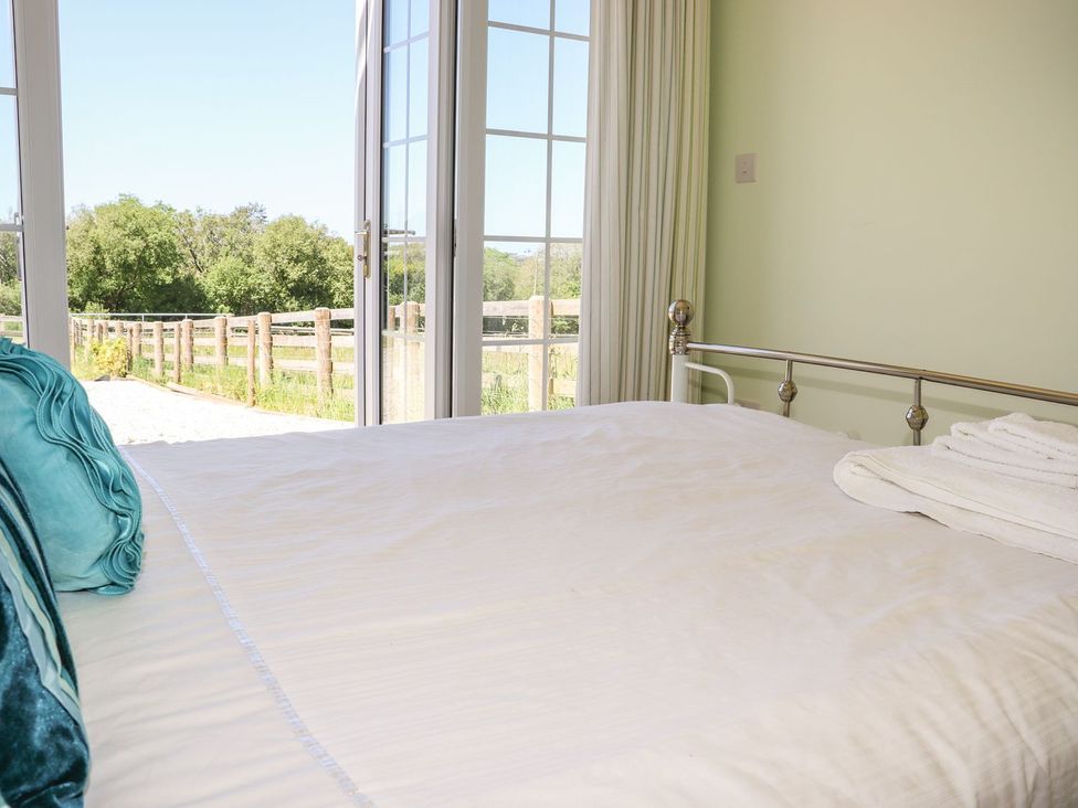 A bedroom with a bed and window at Atlantic View (1 bed) Bude