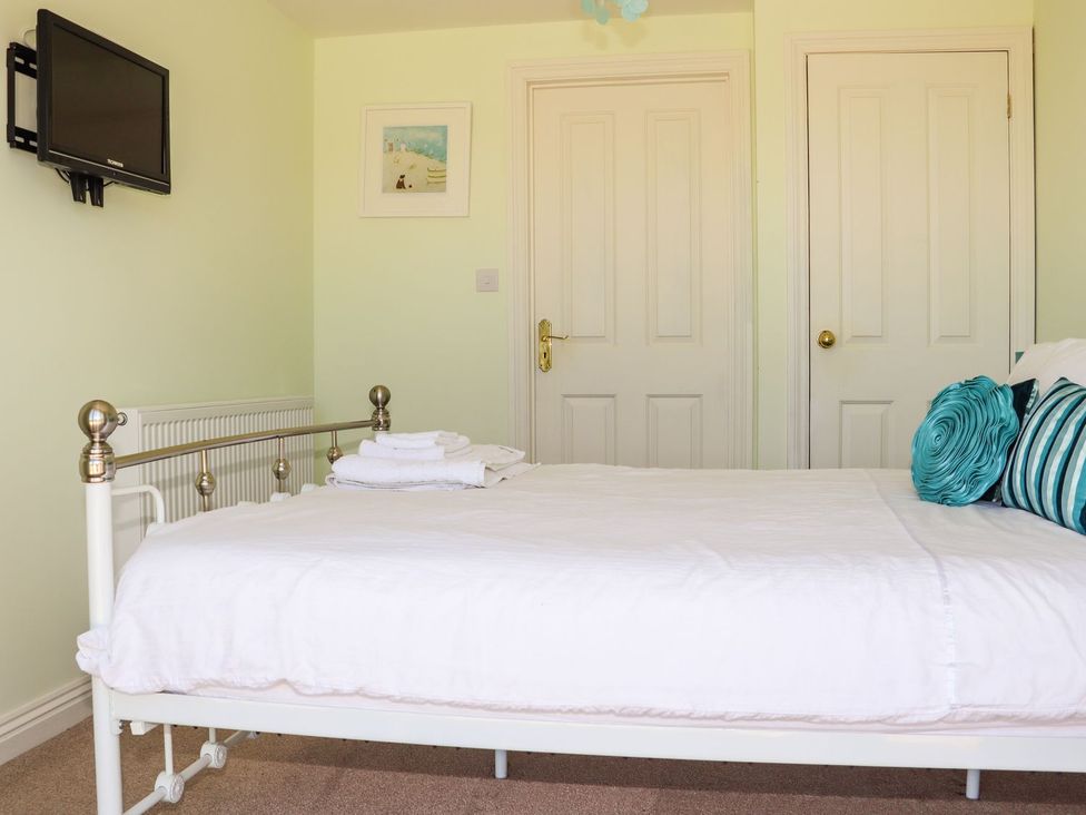 A bedroom with a bed and television at Atlantic View (1 bed) Bude