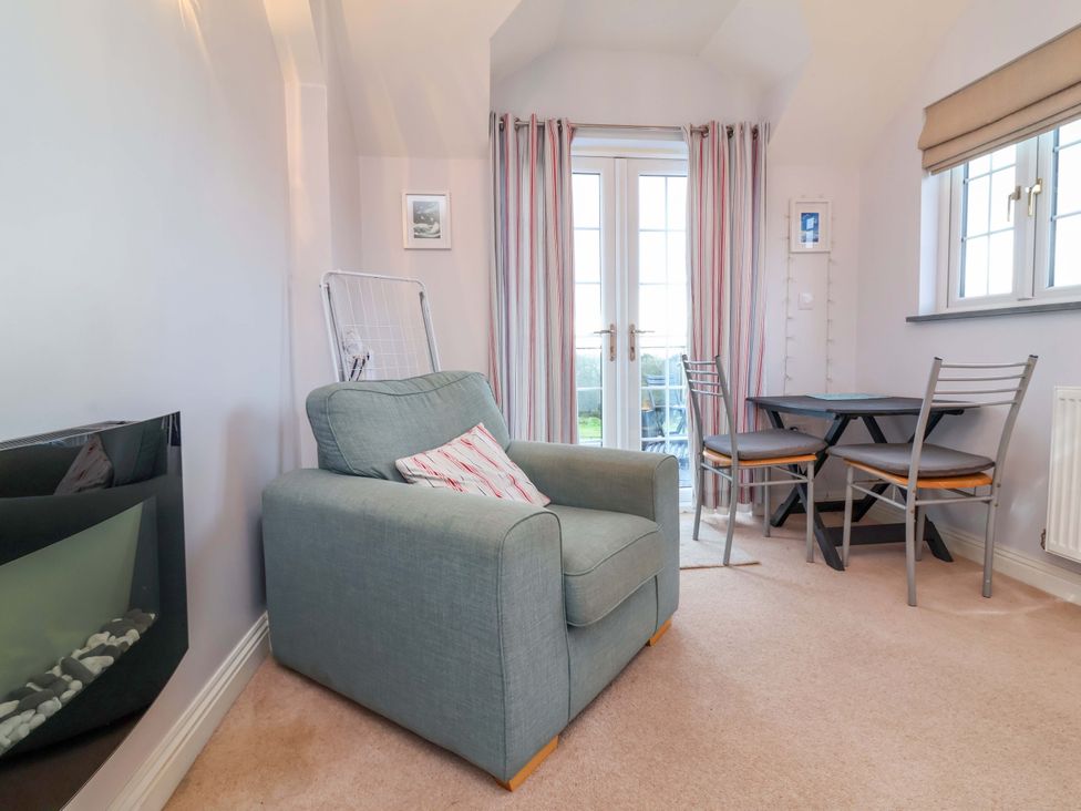 A snug with an armchair and dining table at Atlantic View Apartment Poundstock near Bude