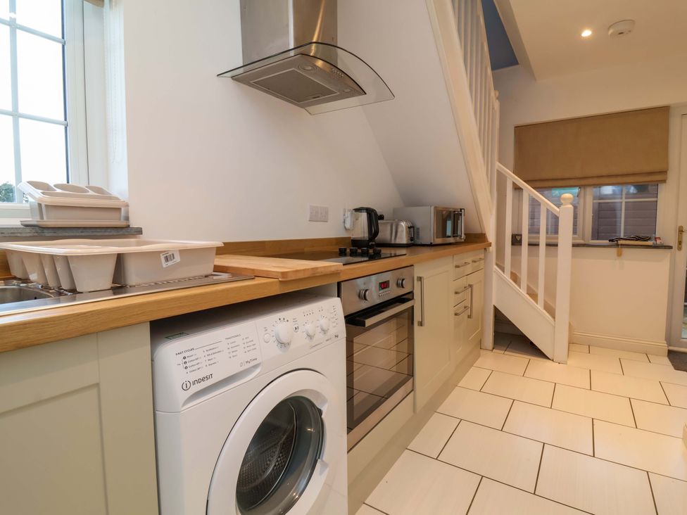 A kitchen with washing machine and stove at Atlantic View Apartment Poundstock near Bude