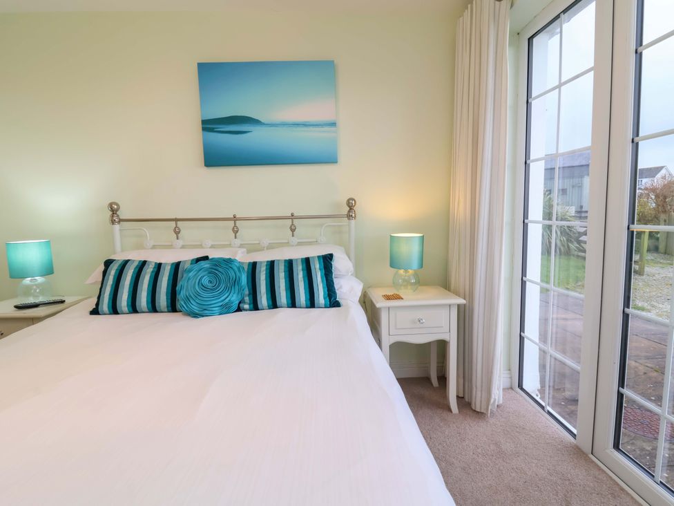 A bedroom with a bed and nightstand at Atlantic View Apartment Poundstock near Bude