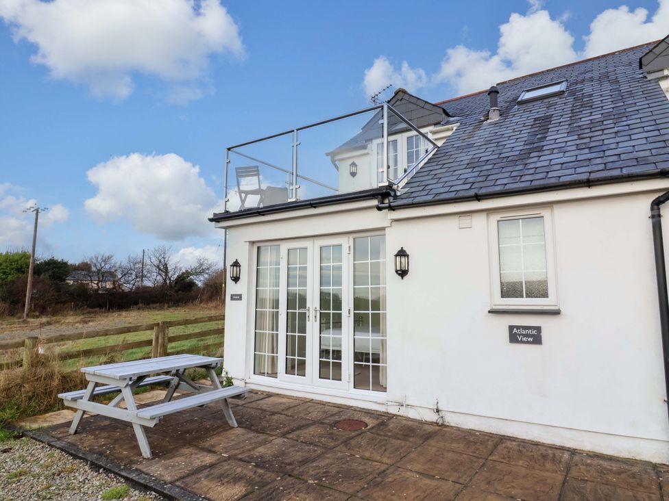 An outdoor area with a table and benches at Atlantic View Apartment Poundstock near Bude