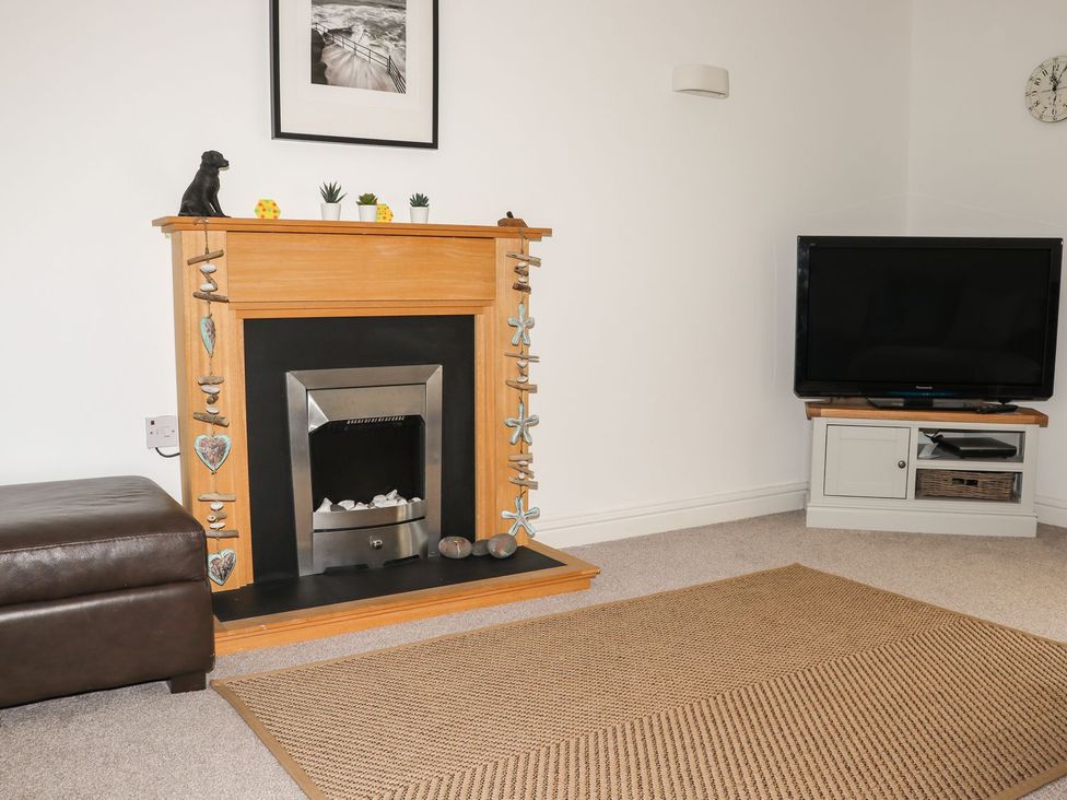 A living room with a fireplace and television at Atlantic View (3 bed) Bude