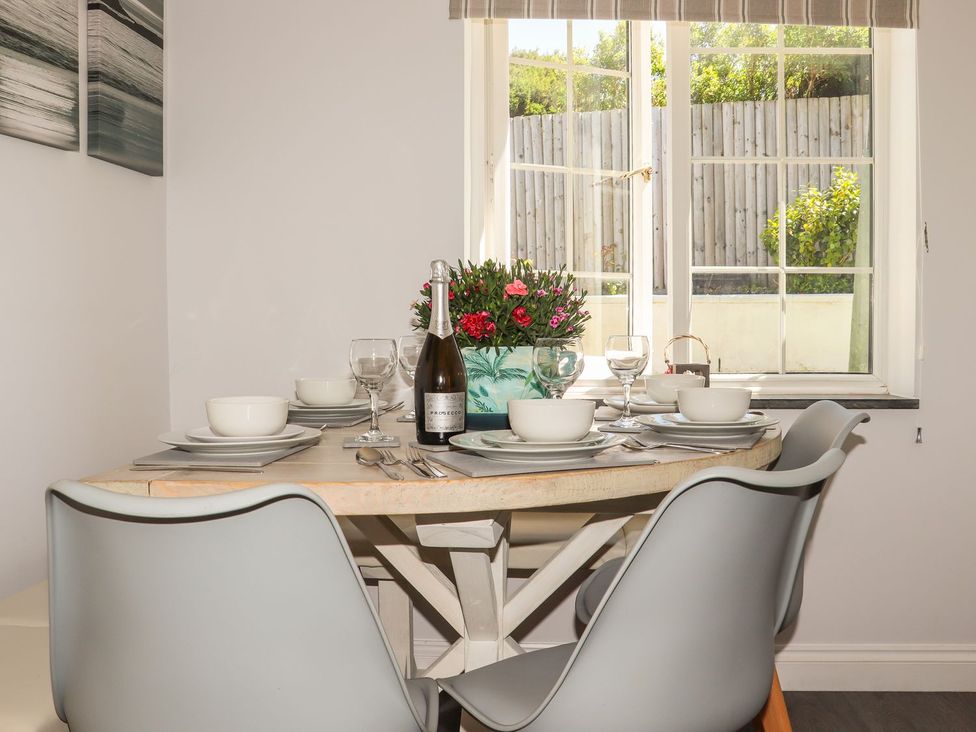 A dining room with a table set for dinner at Atlantic View (3 bed) Bude