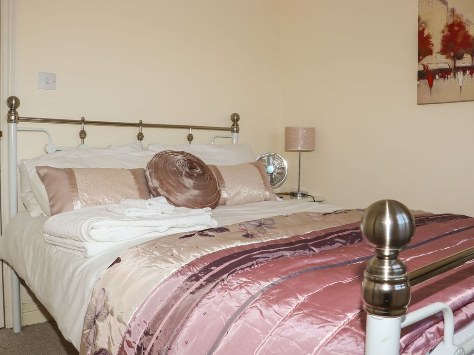 A bedroom with a bed, pillows, and a bedside lamp at Atlantic View (3 bed) in Bude