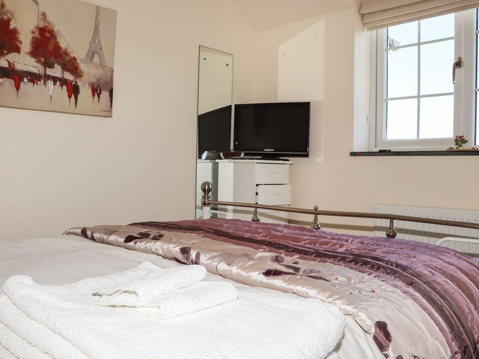 A bedroom with a bed and a television at Atlantic View (3 bed) Bude
