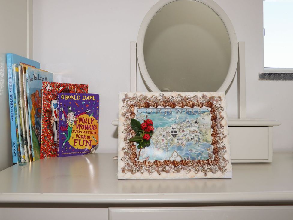 A dresser with books and a decorative frame at Atlantic View (3 bed) in Bude