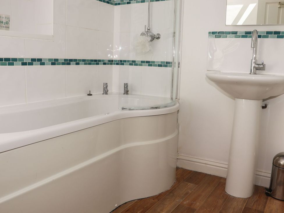 A bathroom with a bath and sink at Atlantic View (3 bed) Bude