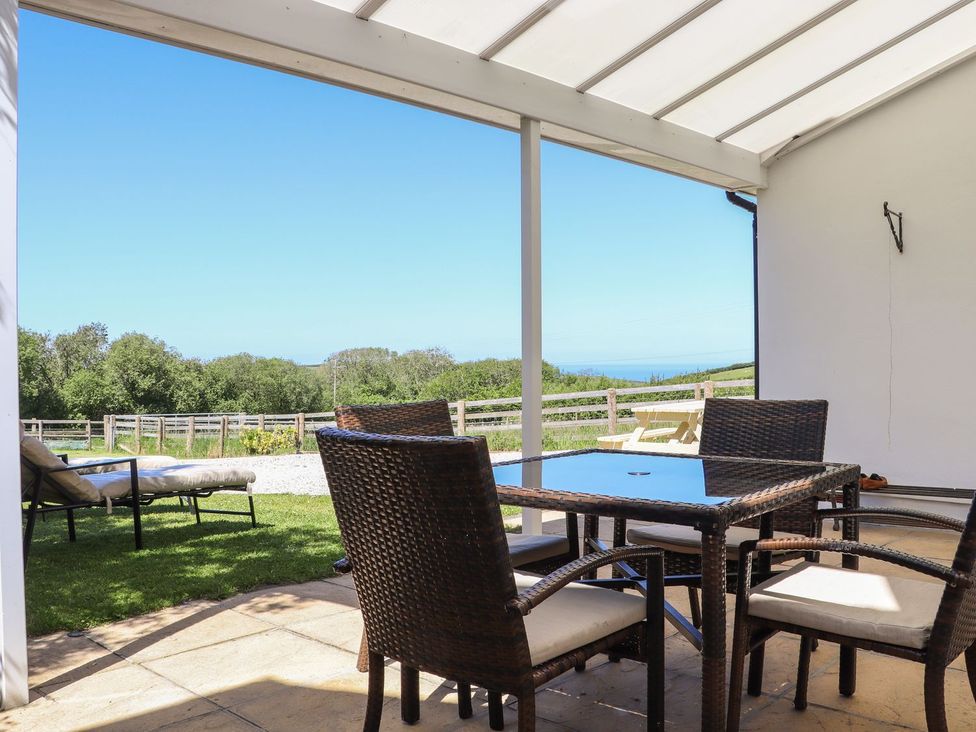 A patio area with a table and chairs at Atlantic View (3 bed) in Bude