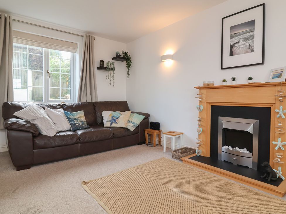 A living room with a sofa and fireplace at Atlantic View in Poundstock near Bude
