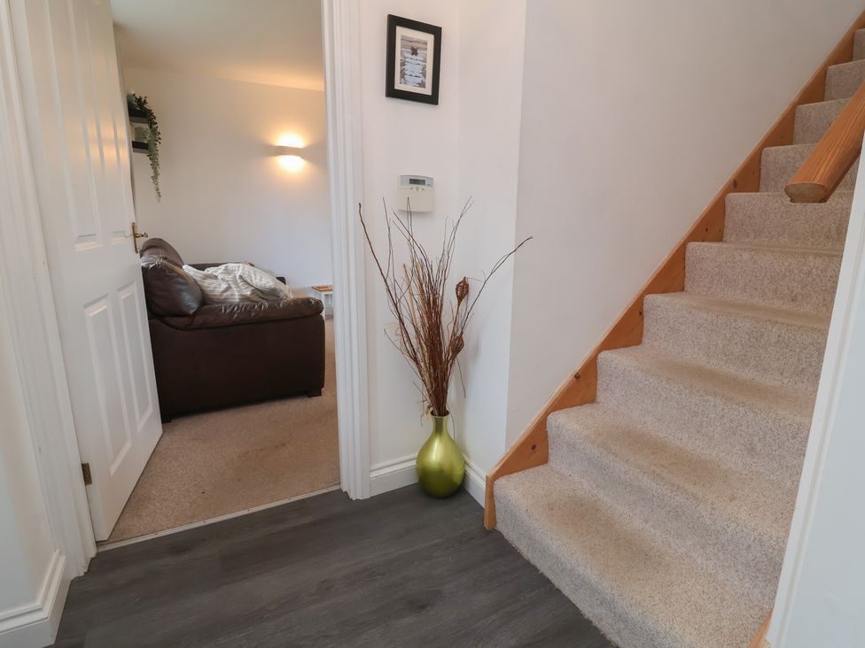 A hallway with a staircase and a sofa visible at Atlantic View Poundstock near Bude