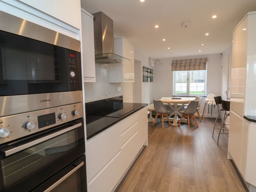 A kitchen with appliances and dining table at Atlantic View Poundstock near Bude