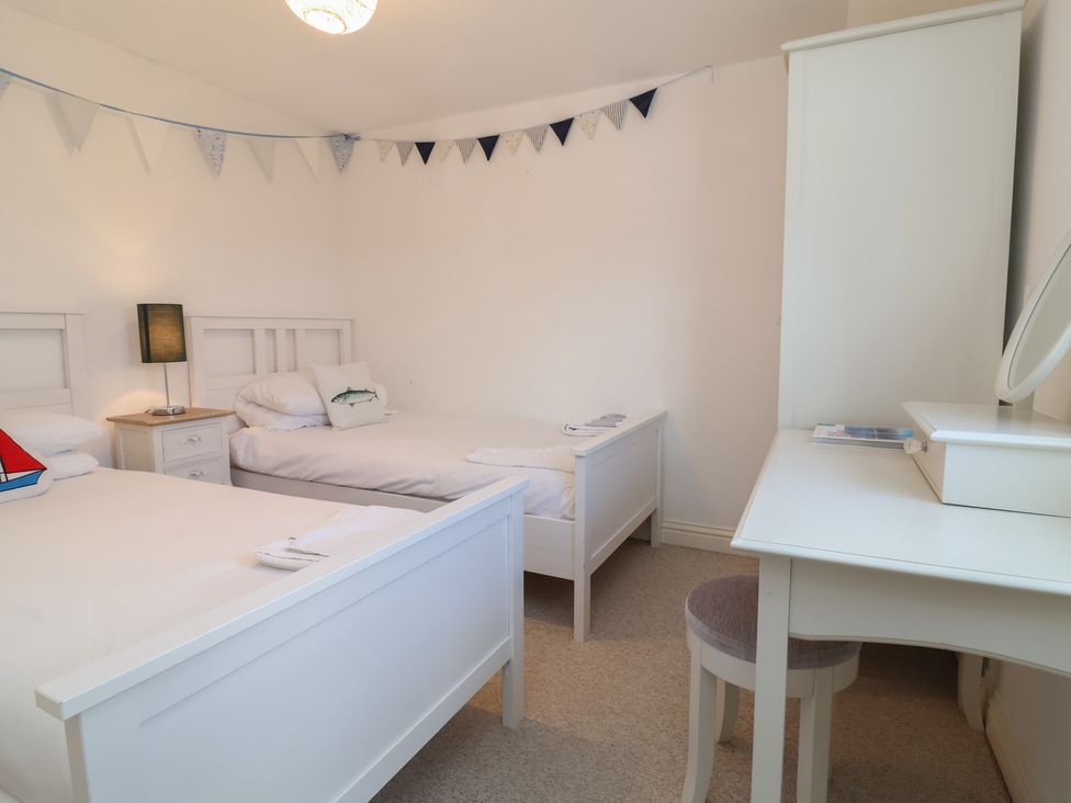 A bedroom with two beds and a table at Atlantic View in Poundstock near Bude