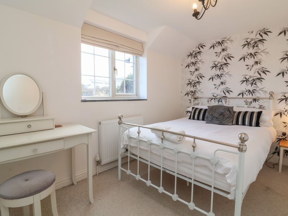 A bedroom with a bed and a dressing table at Atlantic View in Poundstock near Bude