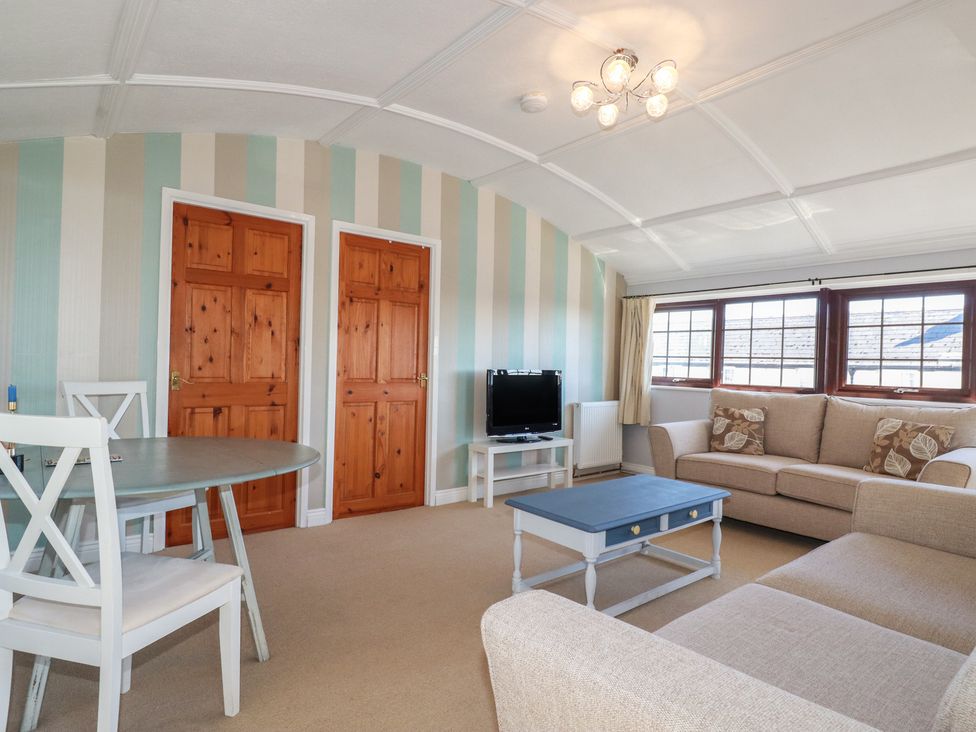 A living room with a sofa, table, and television at The Loft in Truro