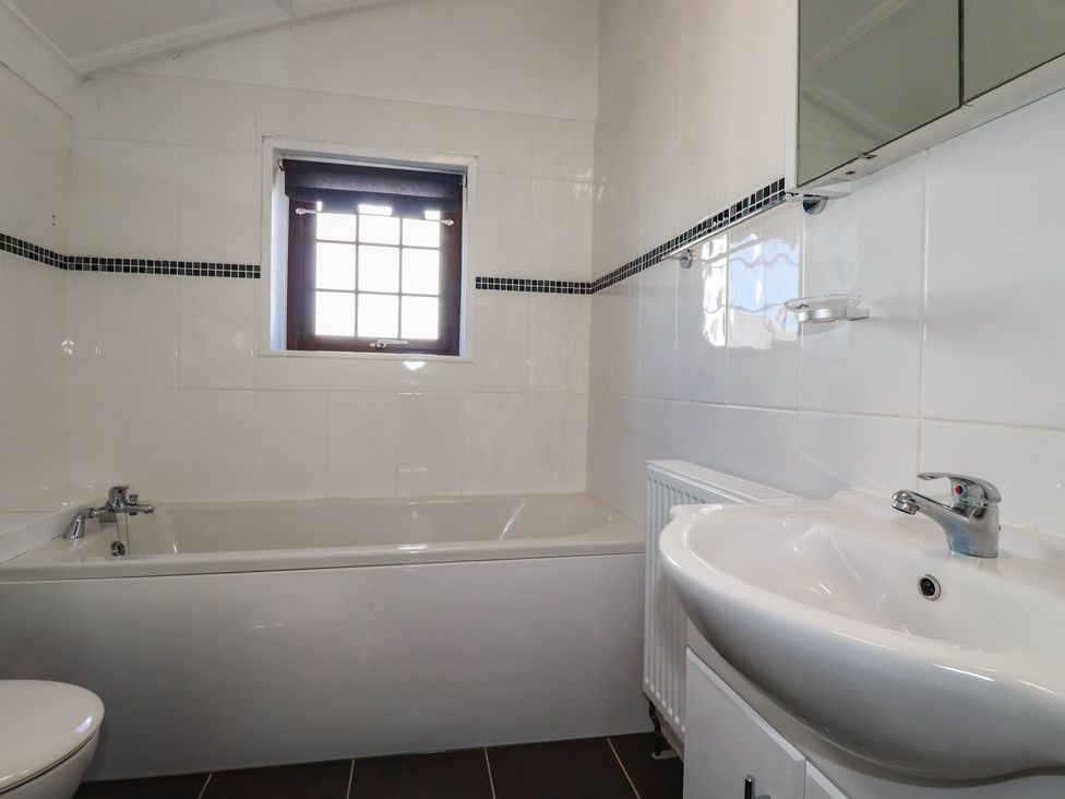 A bathroom with a bathtub, sink, and toilet at The Loft in Truro