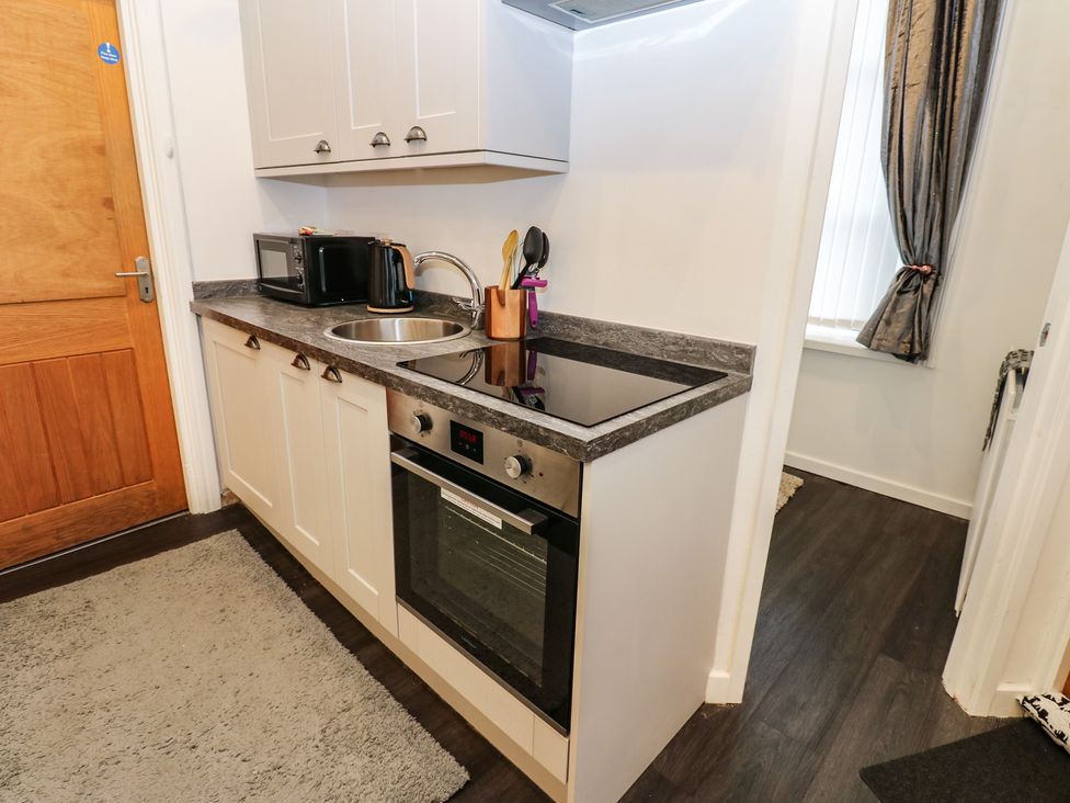A kitchen with a countertop, sink, oven, and microwave at The Railway Apartment in Hexham