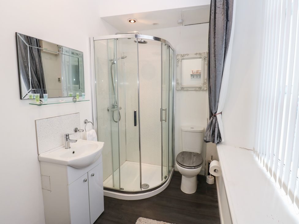 A bathroom with a shower, sink, and toilet at The Railway Apartment in Hexham
