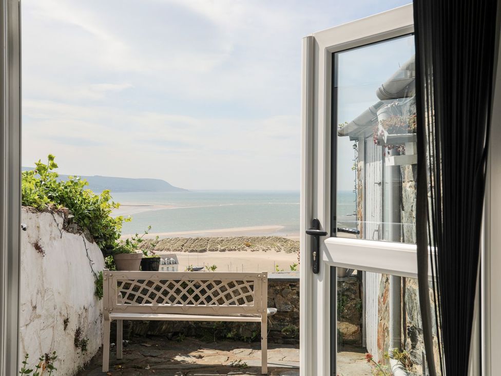 An outdoor area with a bench and a view of the sea at The Ingle in Barmouth