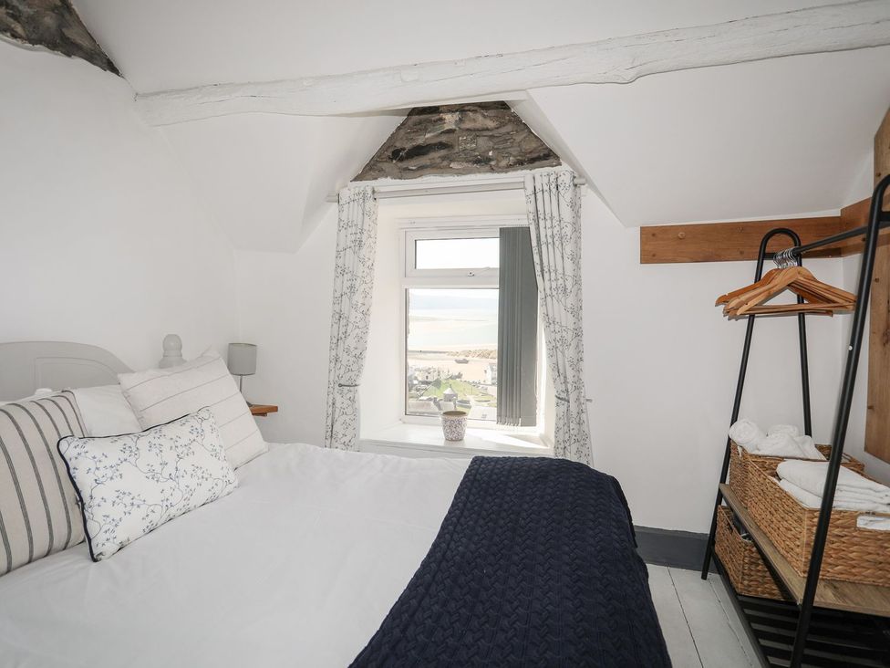 A bedroom with a bed and a window at The Ingle in Barmouth