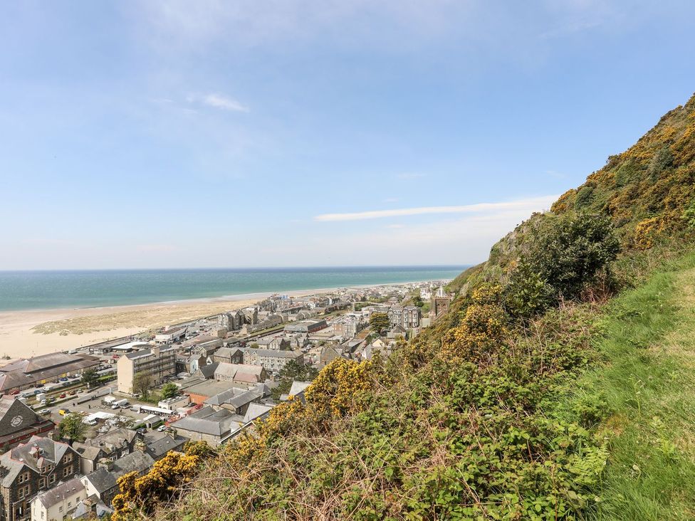 A view of a town and beach from a hill at The Ingle in Barmouth
