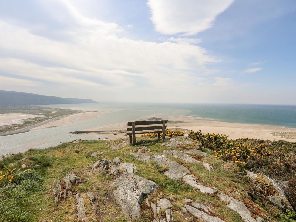 A viewpoint with a bench overlooking water and beach at The Ingle in Barmouth