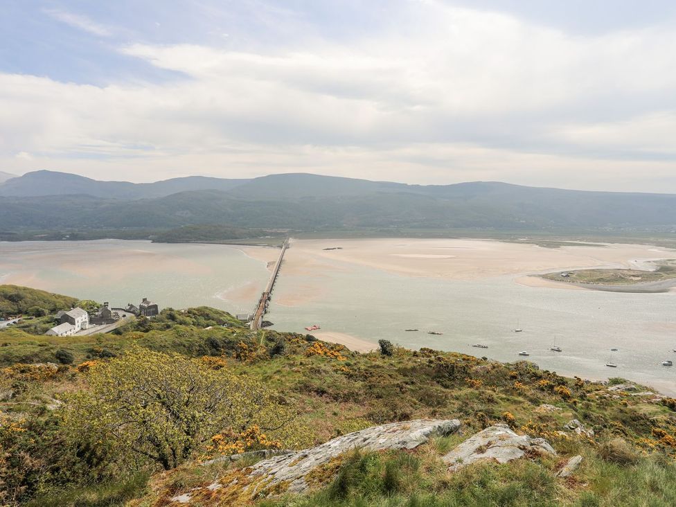 A view of a river and bridge surrounded by mountains at The Ingle in Barmouth