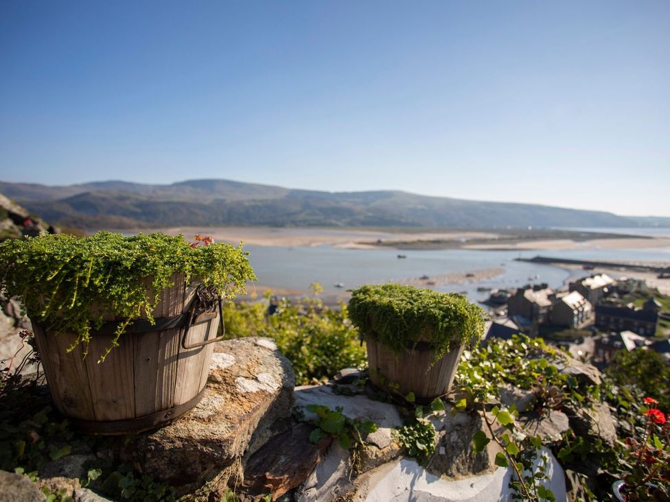 Potted plants overlooking a river and houses at The Ingle in Barmouth