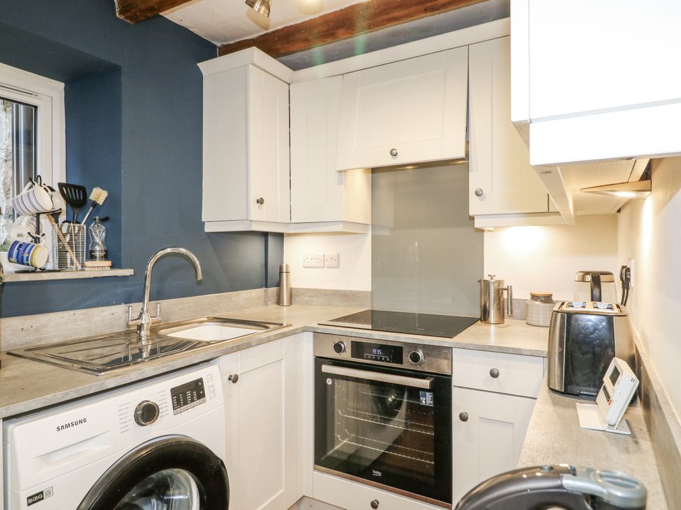 A kitchen with a sink, stove, and washing machine at 5 Belper Lane End, Belper