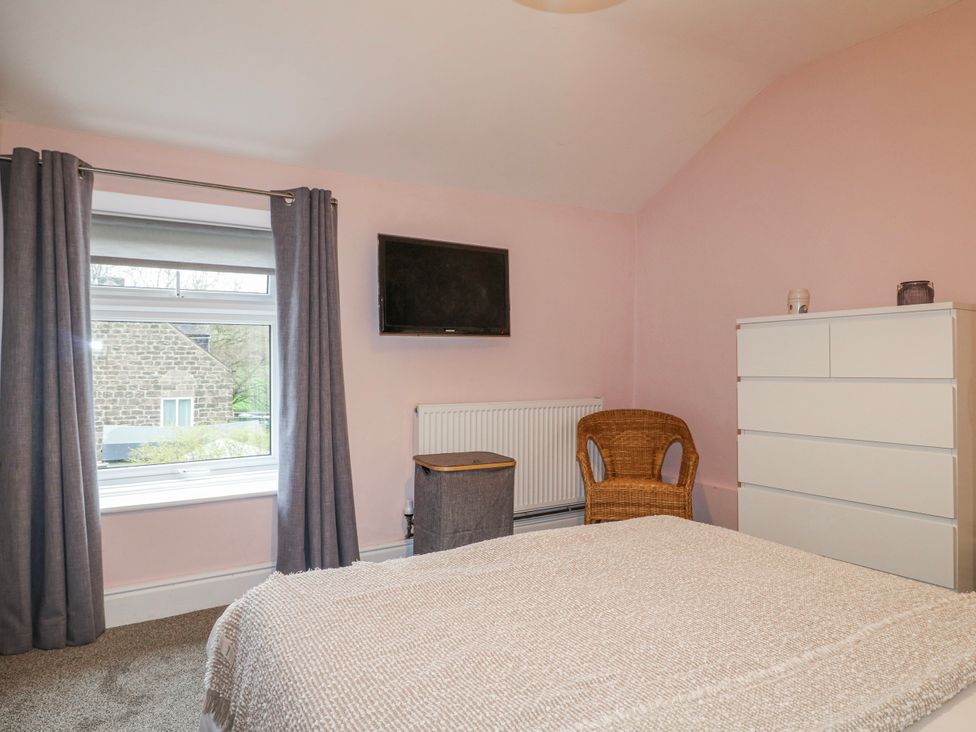 A bedroom with a window and television at 5 Belper Lane End in Belper