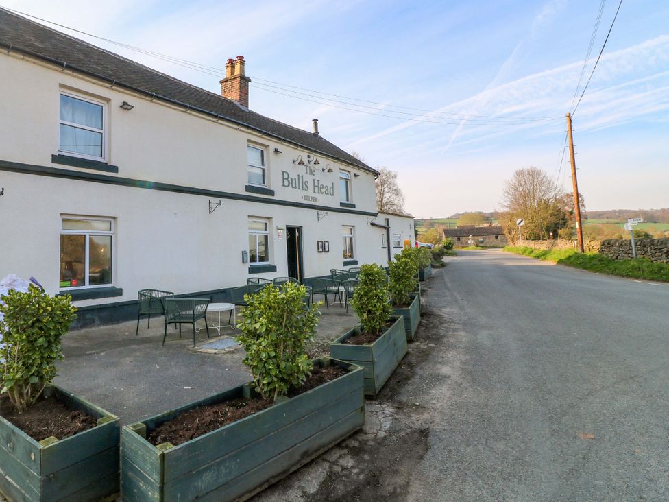 A pub exterior with seating and planters at The Bulls Head in Belper