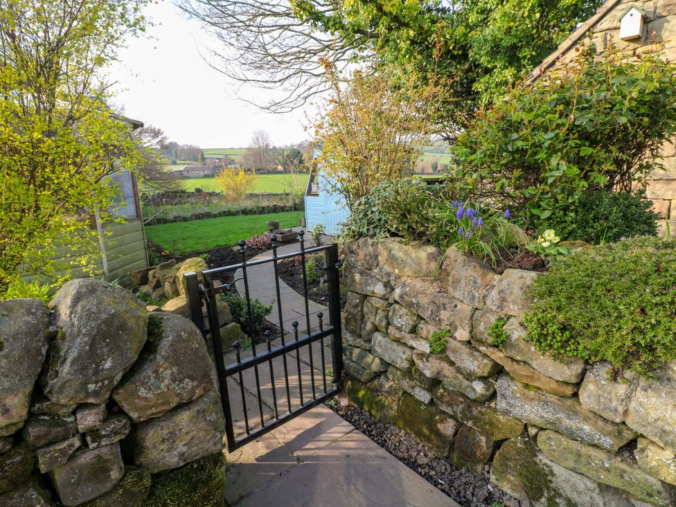 A garden with a stone wall and a pathway at 5 Belper Lane End in Belper