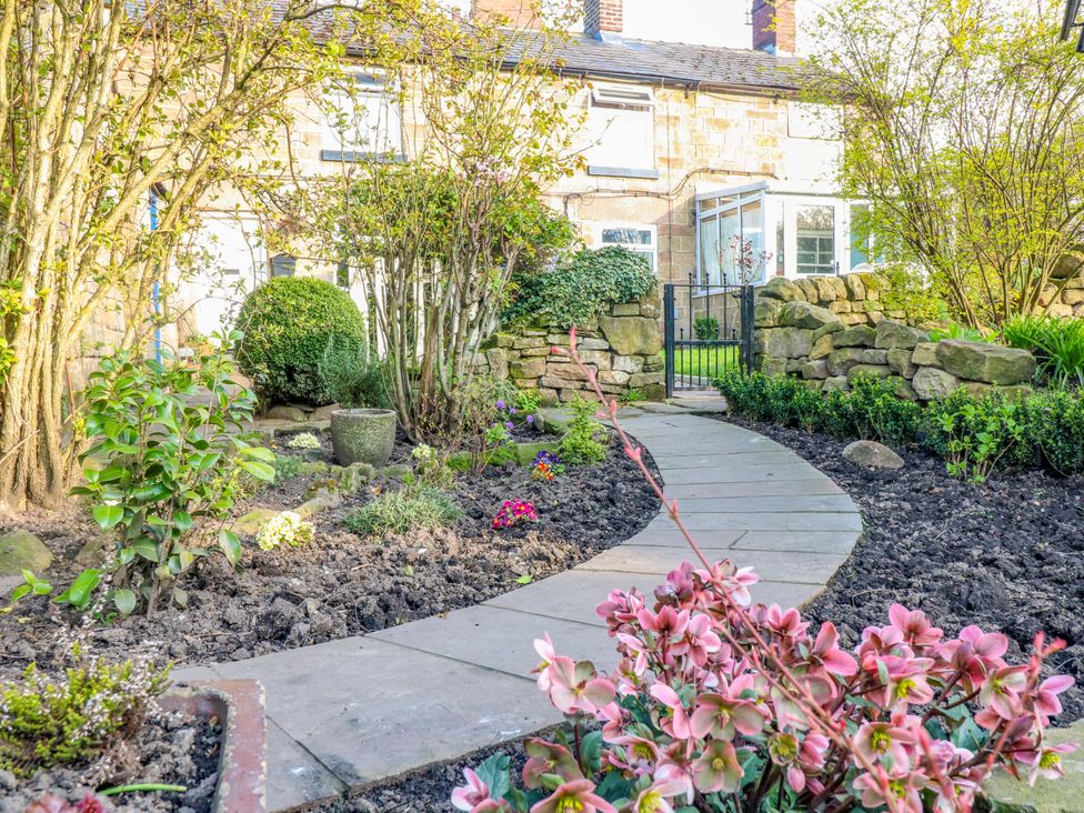 A garden with a stone pathway and flowers at 5 Belper Lane End in Belper