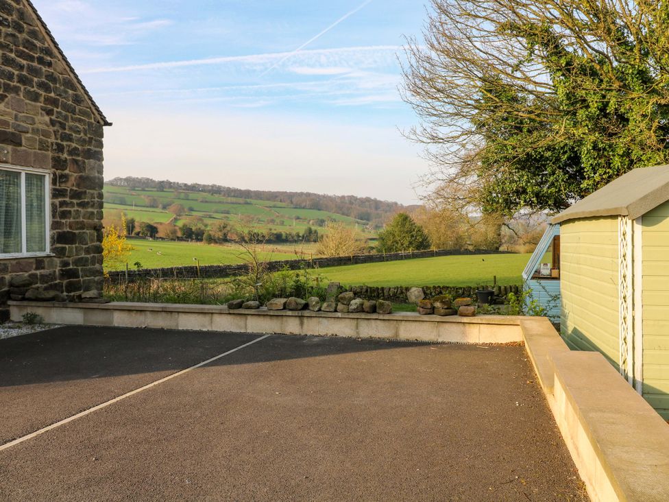 An outdoor area with a stone wall and a parking space at 5 Belper Lane End in Belper