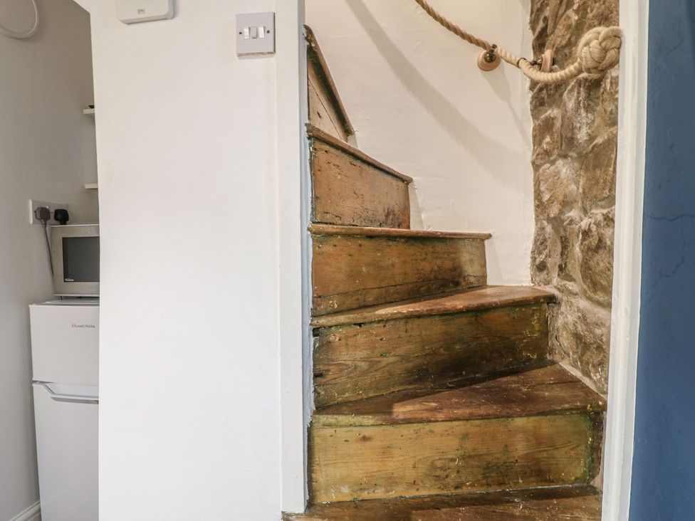 A staircase with wooden steps and a stone wall at 5 Belper Lane End, Belper