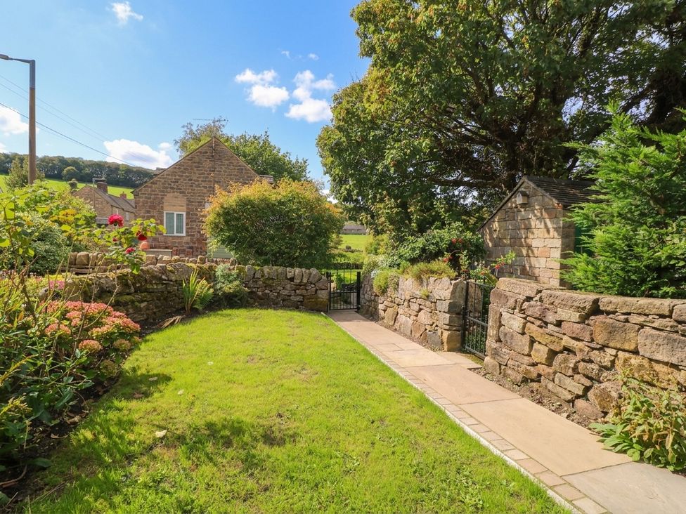 A garden with flowers and a pathway at 5 Belper Lane End in Belper