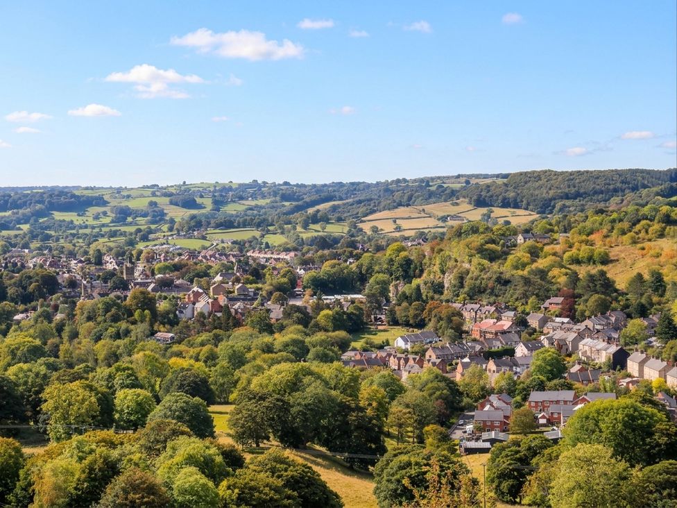 A view of a village surrounded by trees and hills at 5 Belper Lane End in Belper